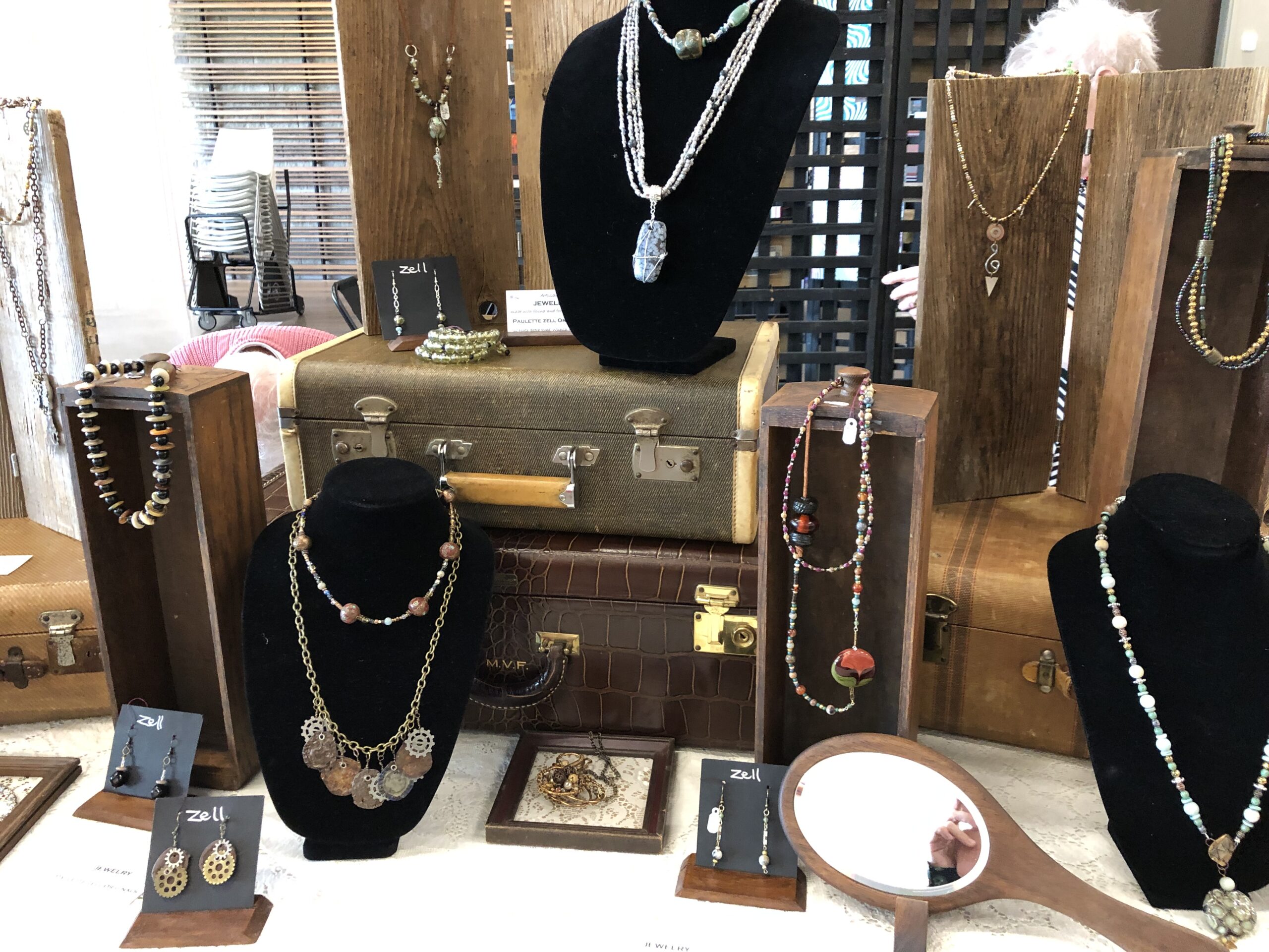 A table of mixed medium jewelry is displayed at Art Market