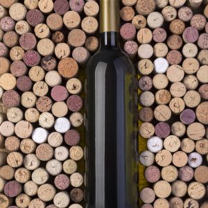 Bottle of white wine and corks on wooden table
